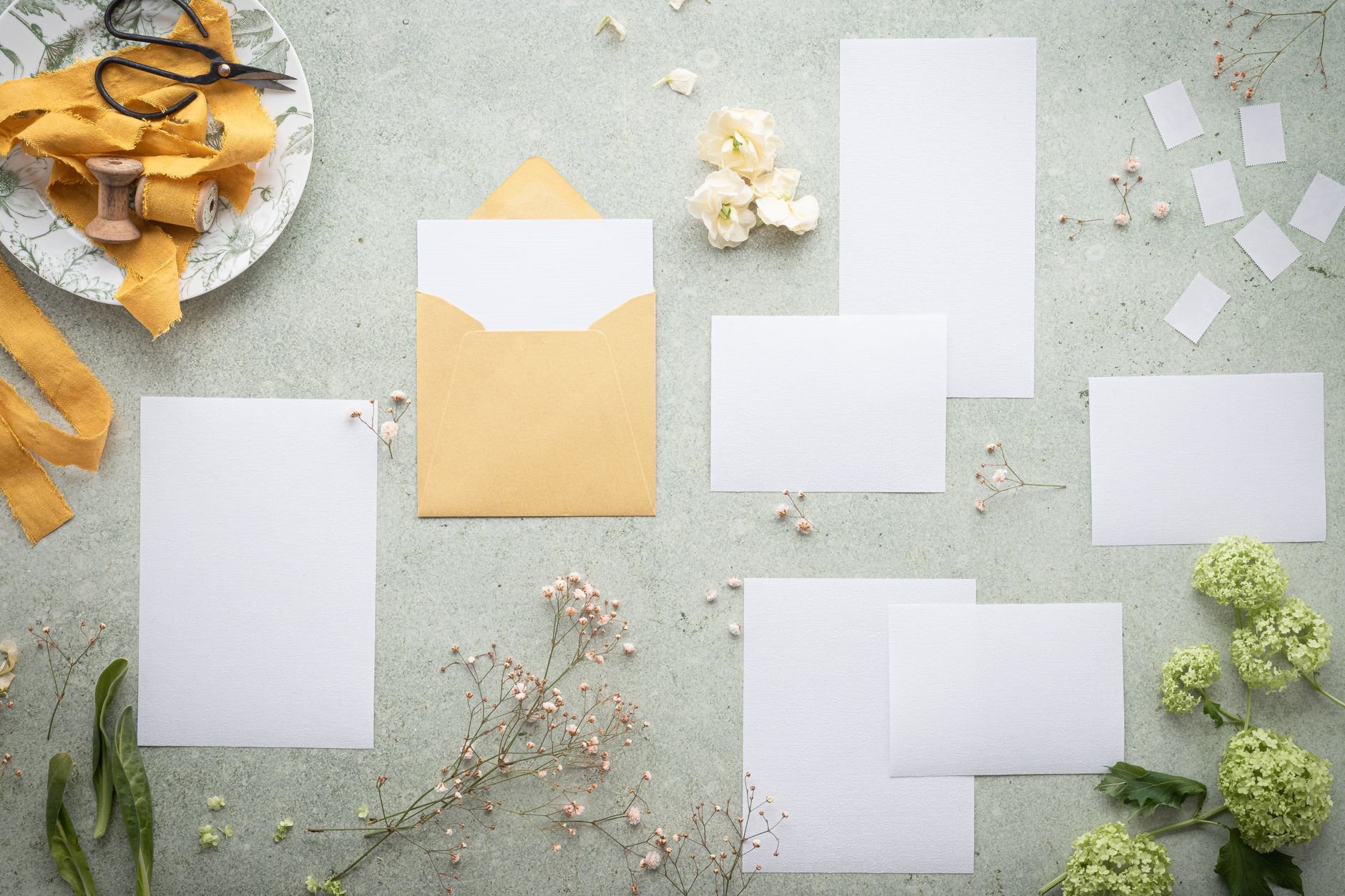 Blank stationery and envelope with delicate flowers — wedding planning flatlay