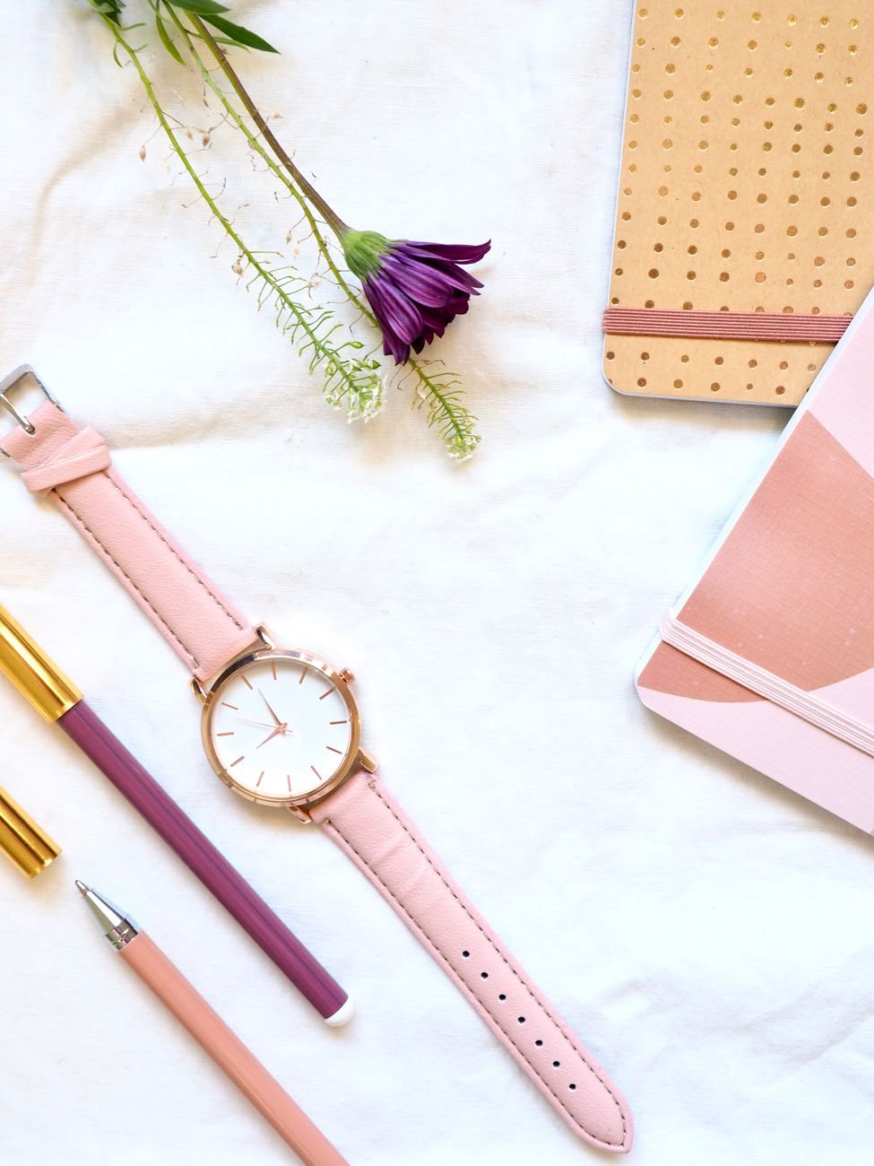 Flat lay of planning notebooks, pens and fresh flowers — wedding organization tools